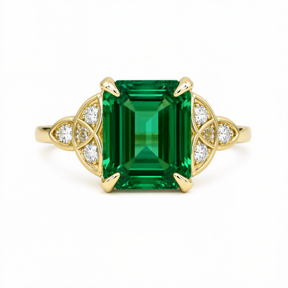 A gold ring with a large, square-cut green gemstone at the center, surrounded by smaller diamonds.