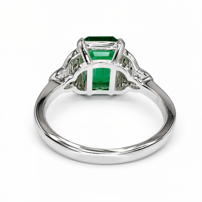 A silver ring with a large, green gemstone set in the center.