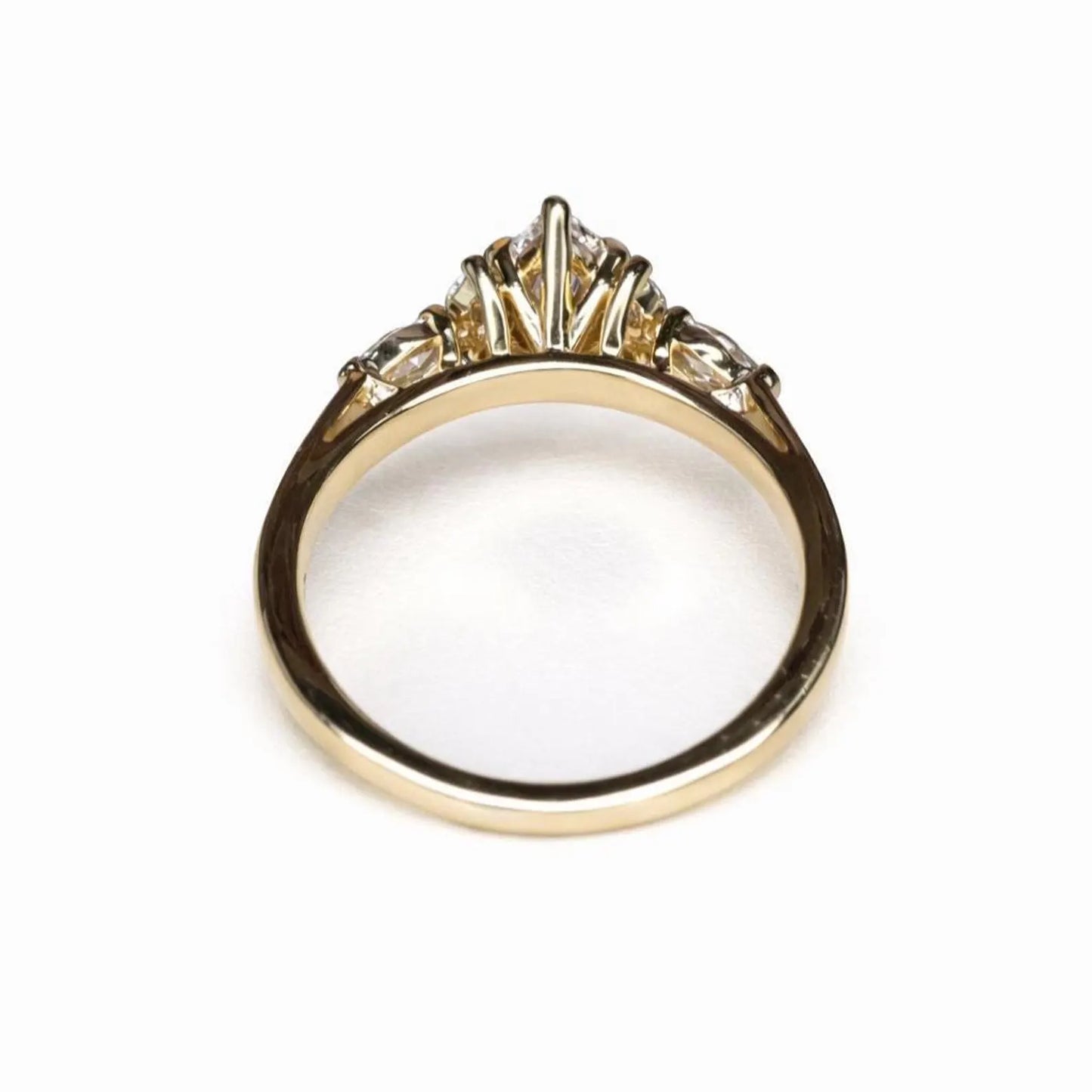 A gold ring with a diamond center stone and three smaller diamonds on either side.