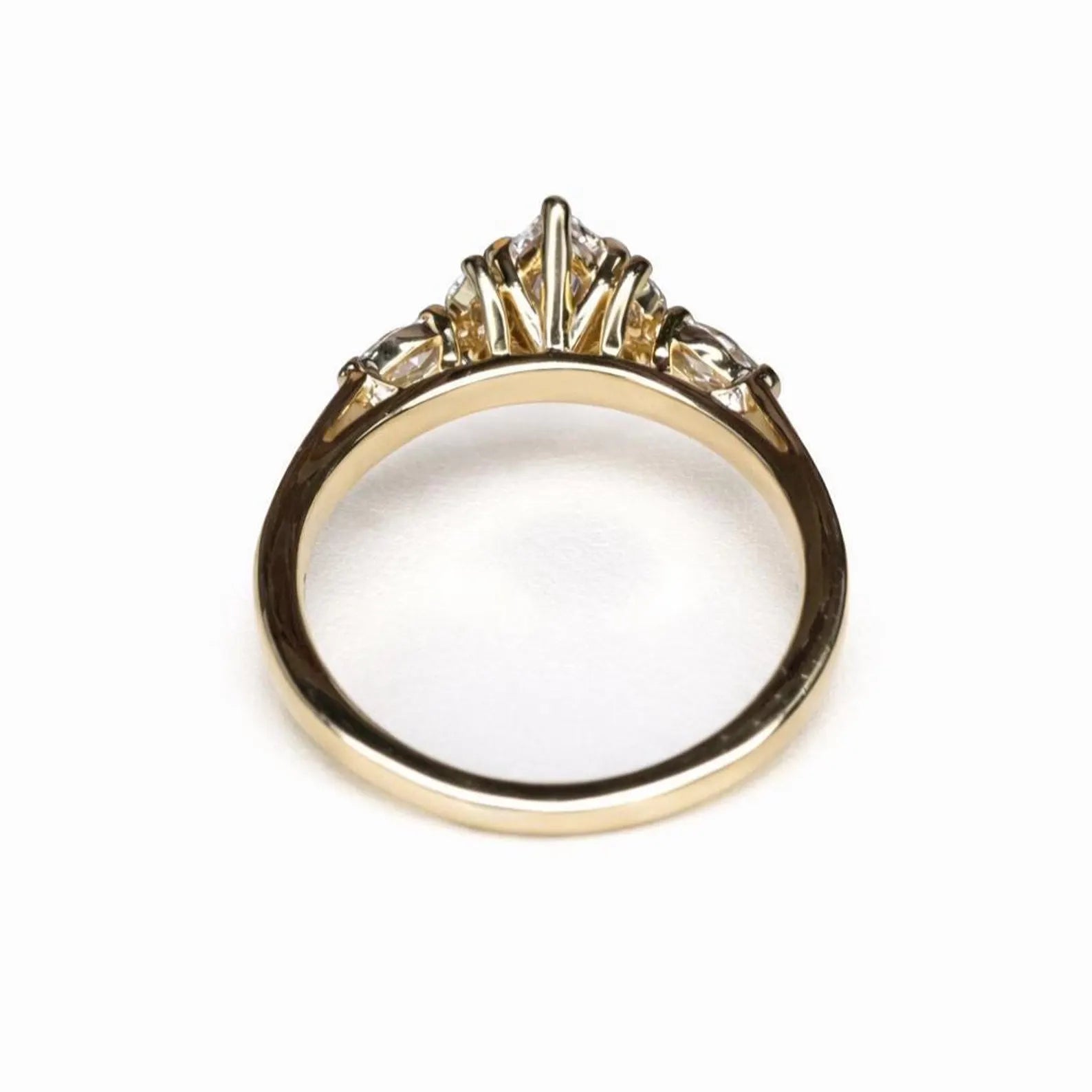 A gold ring with a diamond center stone and three smaller diamonds on either side.
