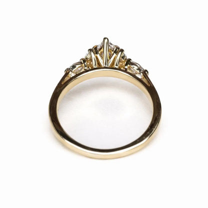 A gold ring with a diamond center stone and three smaller diamonds on either side.