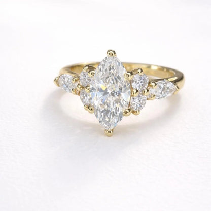 A gold engagement ring with a large central diamond surrounded by smaller diamonds on either side.