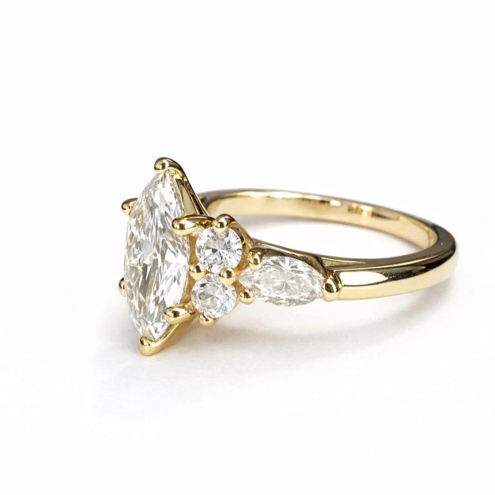 A gold engagement ring with a large diamond set in the center, surrounded by smaller diamonds.