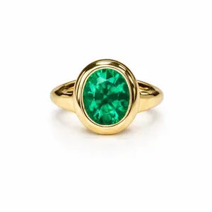 A gold ring with a large oval-shaped green gemstone set in the center.