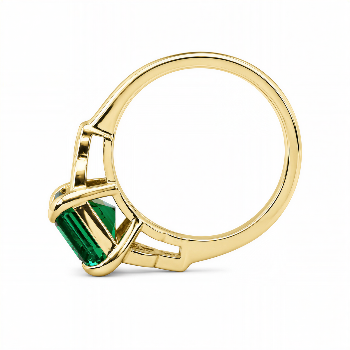 A gold ring with a large green gemstone, possibly an emerald, set in the center.